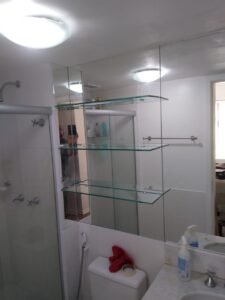 Espelho com prateleiras colocados no banheiro